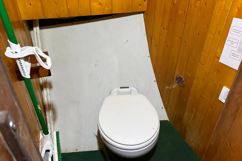 Slide: The Image of Wood-paneled bathroom with toilet on 1992 Treworgy 65 Schooner boat. - 19