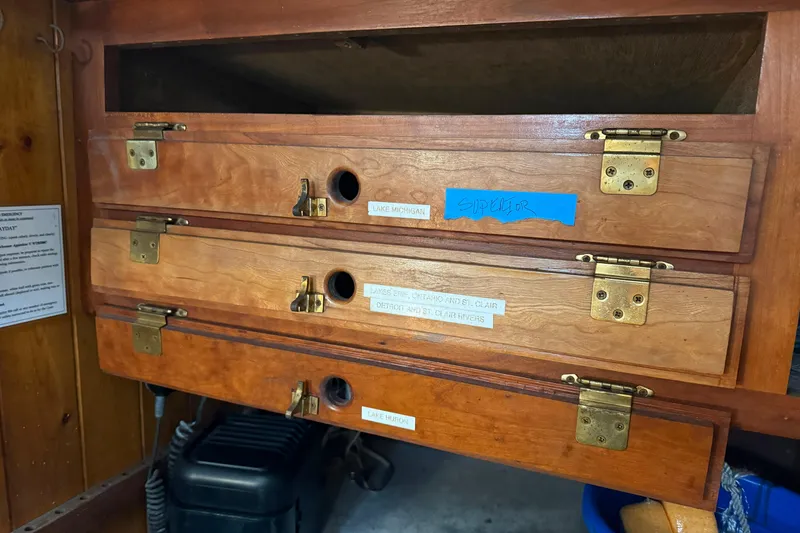 Slide: The Image of Wooden storage drawers labeled with Great Lakes names on a 1992 Treworgy 65 Schooner. - 21