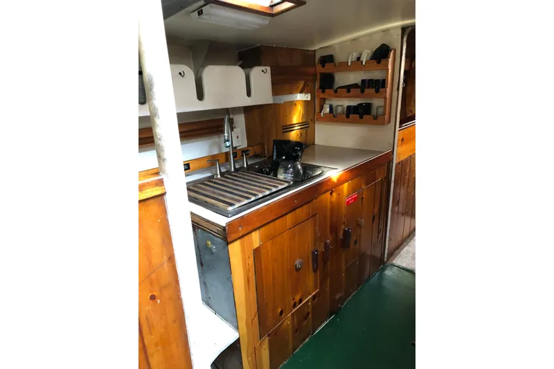 Slide: The Image of 1992 Treworgy 65 Schooner kitchen with wooden cabinets and stainless steel sink. - 24