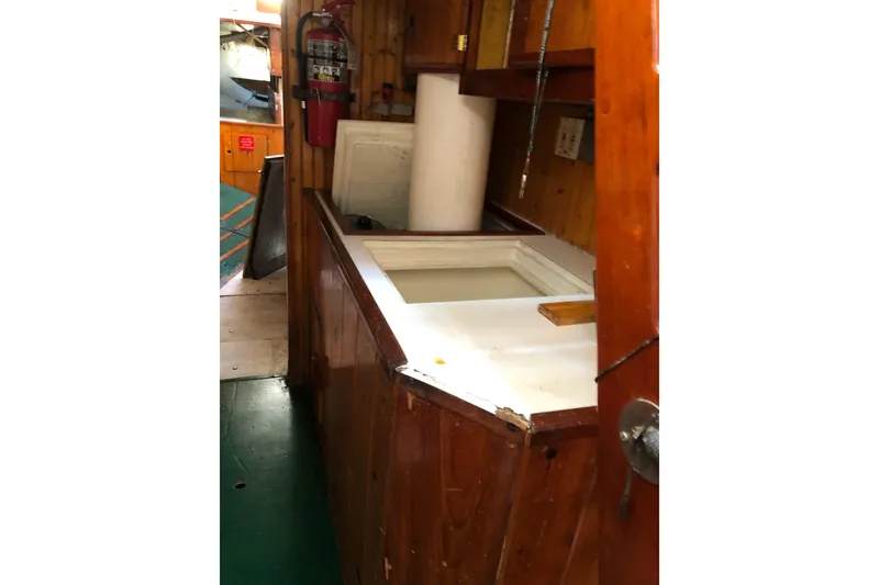 Slide: The Image of Interior of 1992 Treworgy 65 Schooner with wooden cabinetry and fire extinguisher. - 25