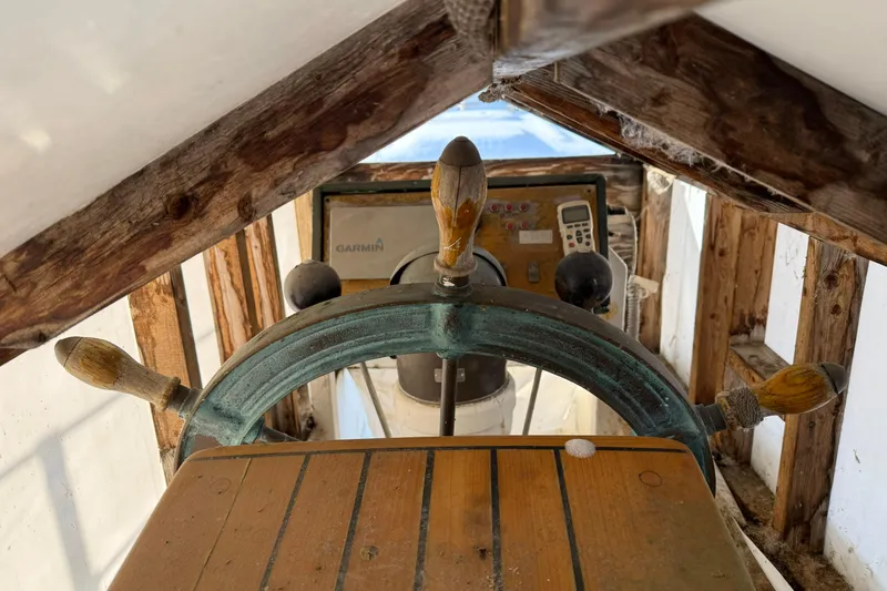 Slide: The Image of Wooden helm of a 1992 Treworgy 65 Schooner with navigation equipment. - 6