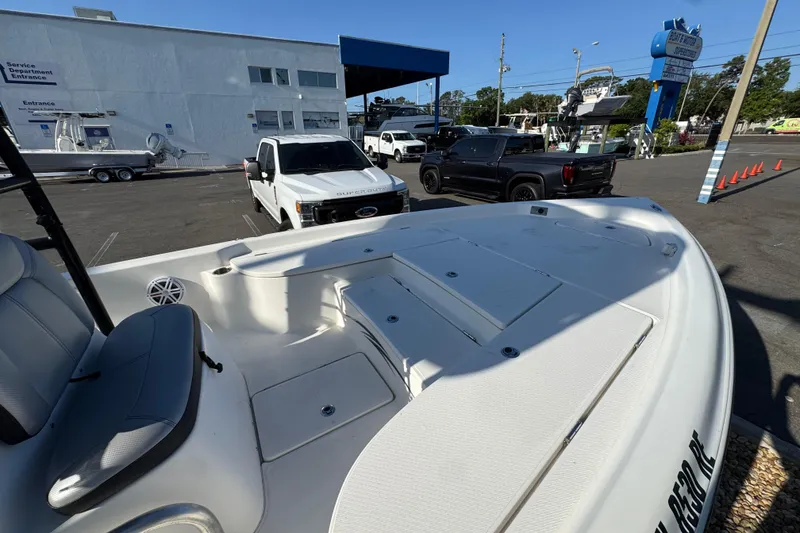 Slide: The Image of 2016 Blue Wave 2200 boat parked at dealership with trucks in background. - 11