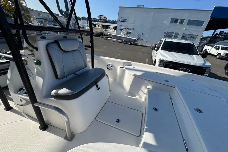 Slide: The Image of 2016 Blue Wave 2200 boat interior with seating, parked near a white truck. - 12
