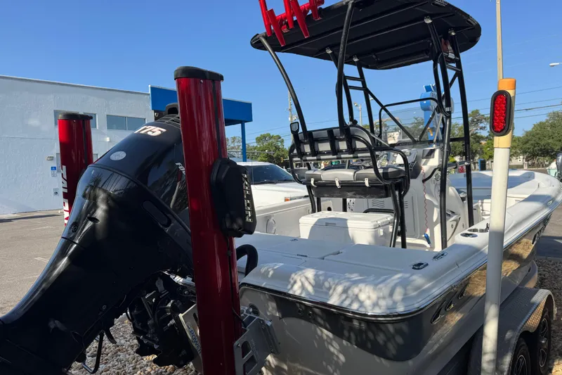 Slide: The Image of 2016 Blue Wave 2200 boat with outboard motor, parked outdoors. - 18