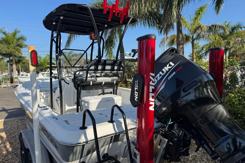Slide: The Image of 2016 Blue Wave 2200 boat with Suzuki engine, parked near palm trees. - 21