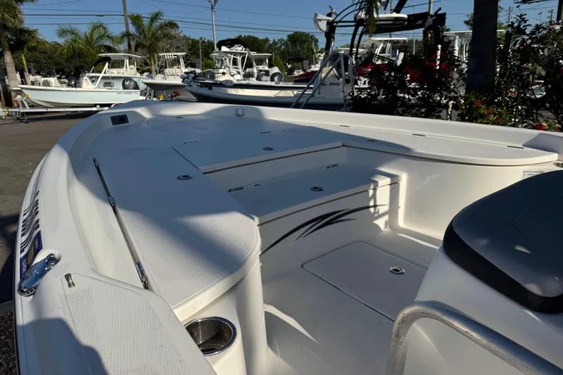 Slide: The Image of 2016 Blue Wave 2200 boat interior with seating and storage, surrounded by other boats. - 24