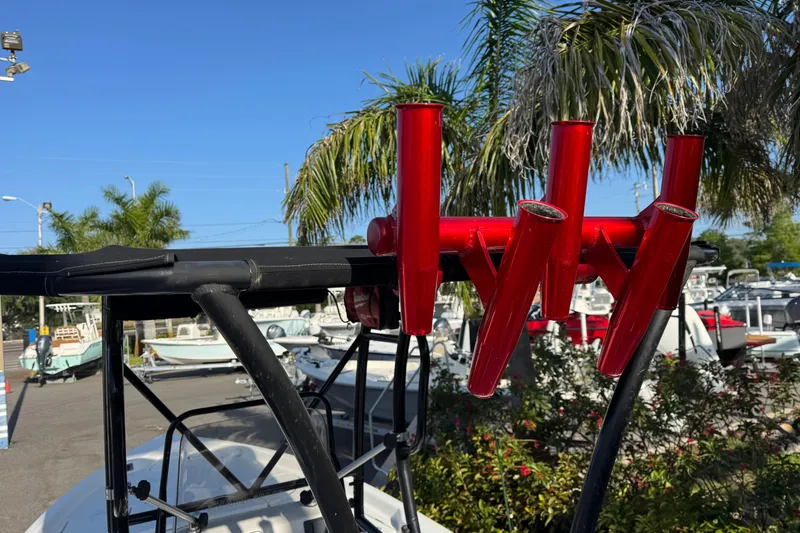 Slide: The Image of 2016 Blue Wave 2200 boat with red rod holders, palm trees in background. - 26