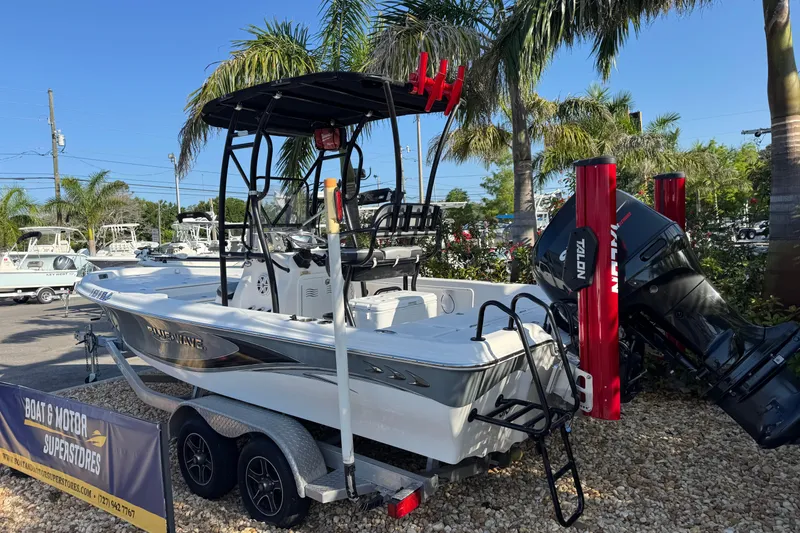 Slide: The Image of 2016 Blue Wave 2200 boat on trailer, displayed outdoors with palm trees. - 3