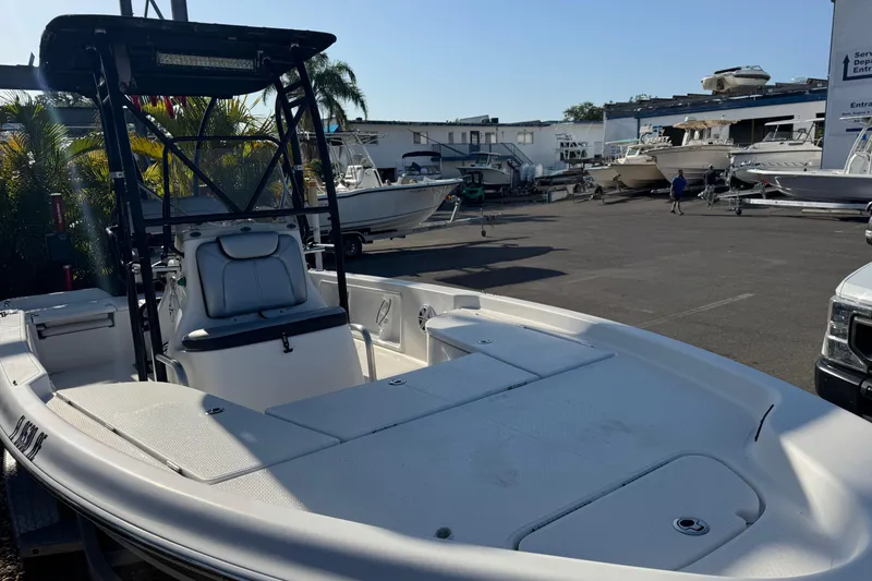 Slide: The Image of 2016 Blue Wave 2200 boat in a marina, surrounded by other vessels and palm trees. - 8