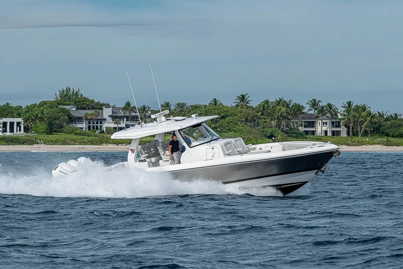 Slide: The Image of 2023 Intrepid 427 Nomad SE cruising on ocean near tropical coastline. - 103