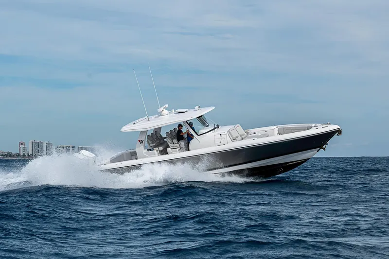 Slide: The Image of 2023 Intrepid 427 Nomad SE cruising on ocean waves, city skyline in background. - 106