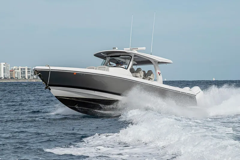 Slide: The Image of 2023 Intrepid 427 Nomad SE cruising on ocean waves near city skyline. - 114