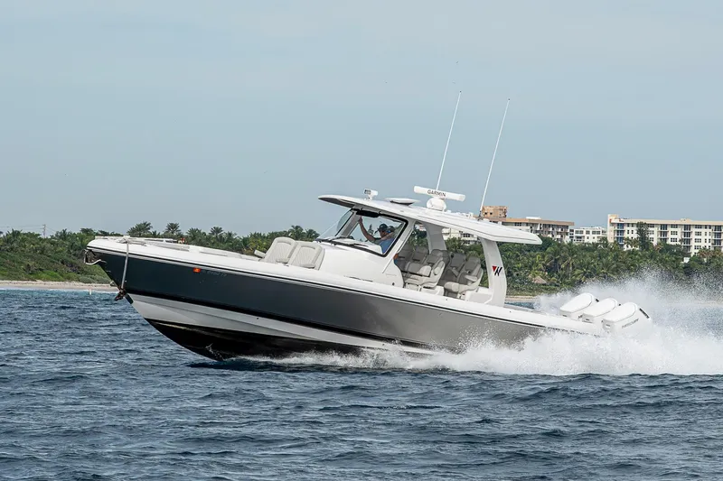 Slide: The Image of 2023 Intrepid 427 Nomad SE boat cruising on open water near coastline. - 116