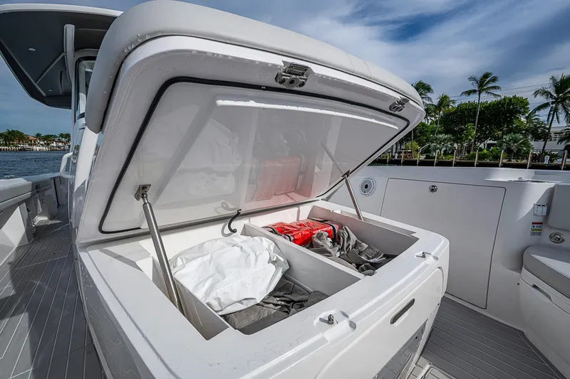 Slide: The Image of 2023 Intrepid 427 Nomad SE boat with open storage compartment, dockside view. - 12