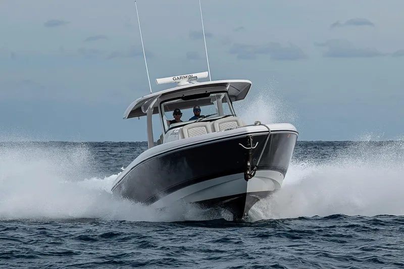 Slide: The Image of 2023 Intrepid 427 Nomad SE boat cruising on open water, creating splashes. - 125