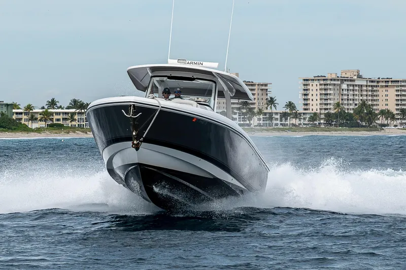 Slide: The Image of 2023 Intrepid 427 Nomad SE cruising on ocean near coastal buildings. - 128