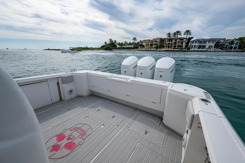 Slide: The Image of 2023 Intrepid 427 Nomad SE boat with triple engines, coastal view, luxury waterfront homes. - 20