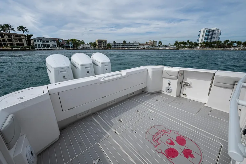 Slide: The Image of 2023 Intrepid 427 Nomad SE boat deck with triple Mercury engines, coastal view. - 21