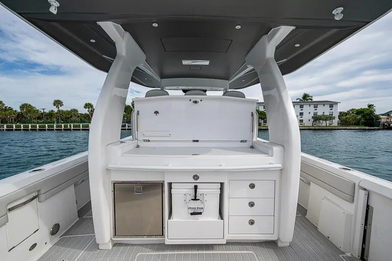 Slide: The Image of 2023 Intrepid 427 Nomad SE boat interior with storage and seating, dockside view. - 30