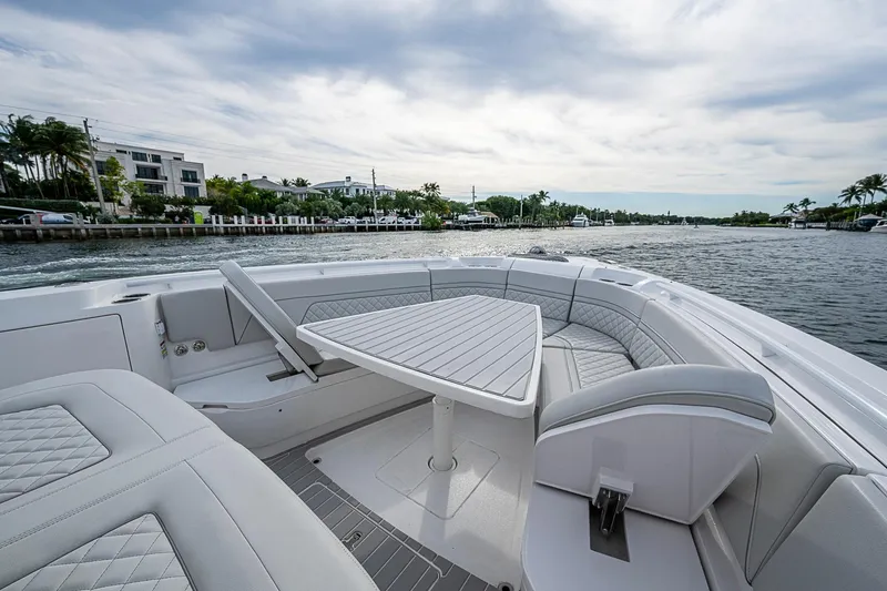 Slide: The Image of Luxurious 2023 Intrepid 427 Nomad SE boat interior with elegant seating and table on a scenic waterway. - 5