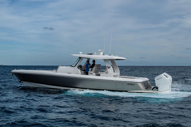 Slide: The Image of 2023 Intrepid 427 Nomad SE cruising on open water under a cloudy sky. - 58