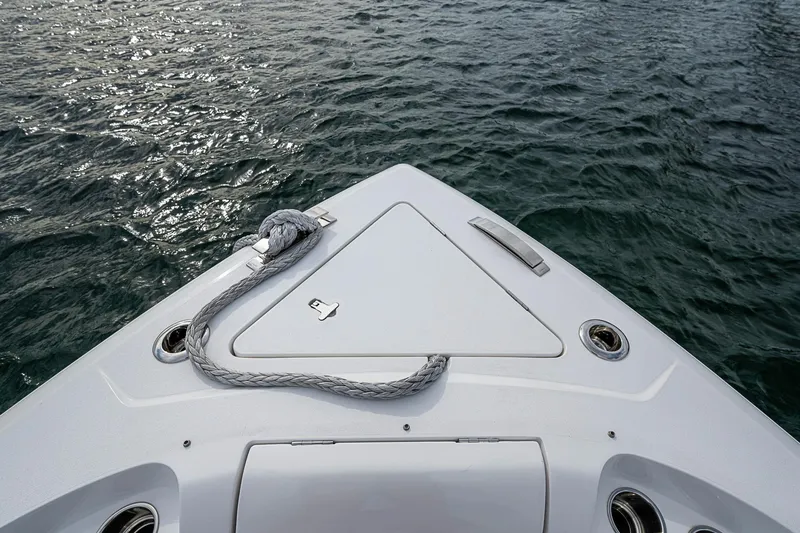 Slide: The Image of Bow of 2023 Intrepid 427 Nomad SE on water, featuring sleek design and rope detail. - 6