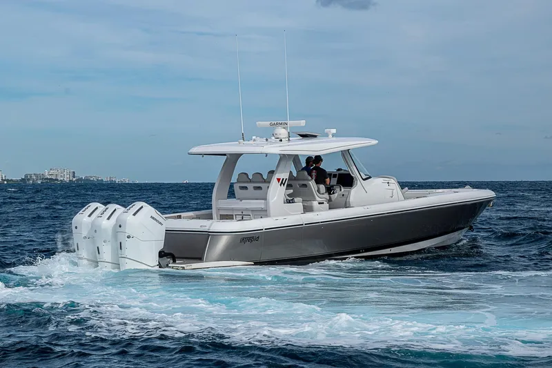 Slide: The Image of 2023 Intrepid 427 Nomad SE cruising on open water with triple outboard engines. - 62