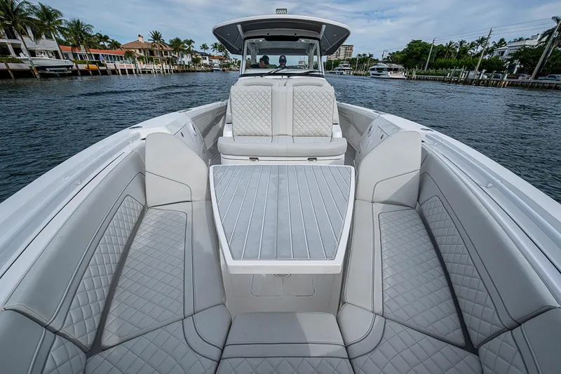 Slide: The Image of 2023 Intrepid 427 Nomad SE luxury boat interior with quilted seating on the water. - 7