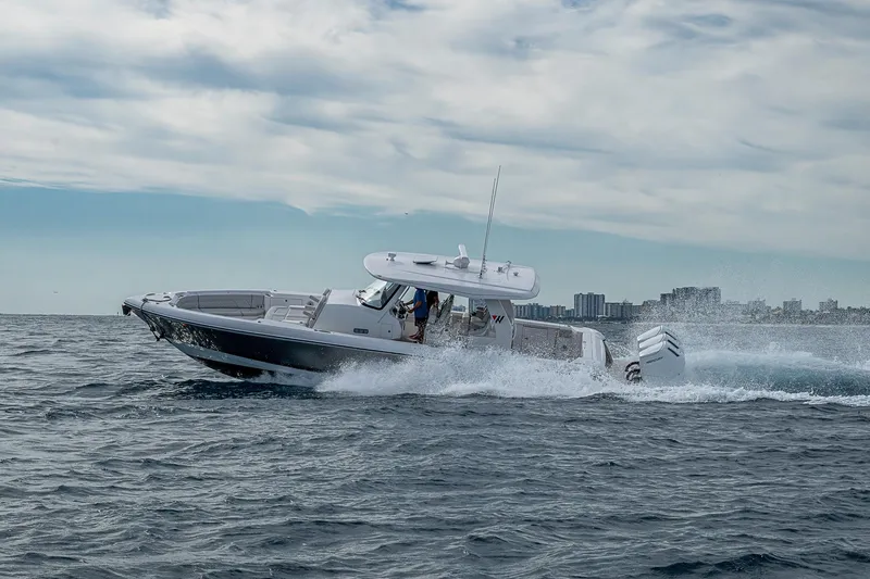 Slide: The Image of 2023 Intrepid 427 Nomad SE cruising on open water with city skyline backdrop. - 91