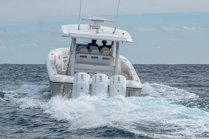 Slide: The Image of 2023 Intrepid 427 Nomad SE boat cruising on open water, rear view. - 92