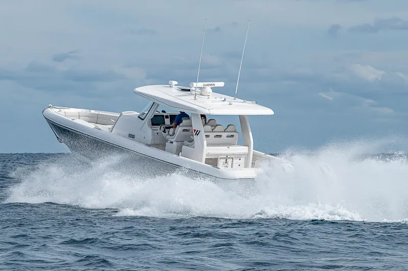 Slide: The Image of 2023 Intrepid 427 Nomad SE cruising on open water, creating dynamic waves. - 98