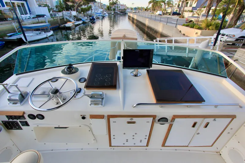 Slide: The Image of 1980 Bertram 35 Flybridge helm with steering wheel, controls, and navigation equipment. - 20