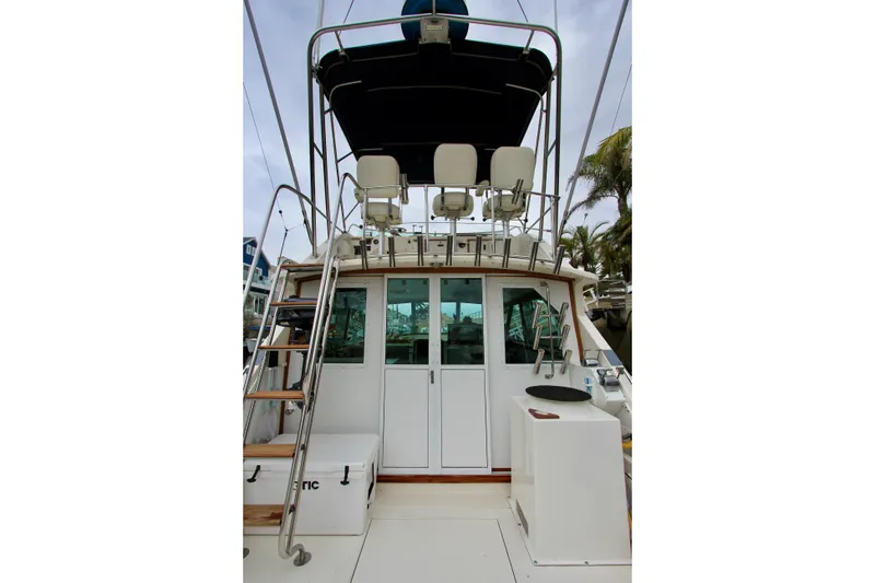 Slide: The Image of 1980 Bertram 35 Flybridge boat with ladder and seating area. - 23