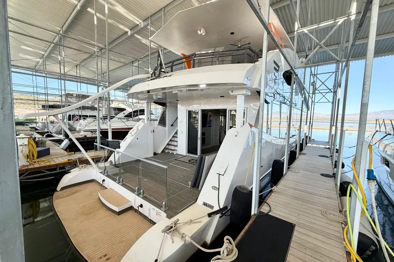 Slide: The Image of 2021 BRAVADA YACHTS Atlas V Series 8018 docked in a marina under a metal canopy. - 68
