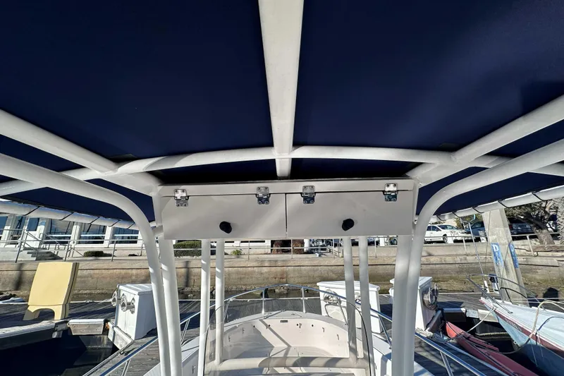 Slide: The Image of 2018 Robalo R200 Center Console boat with blue canopy and sturdy frame. - 12