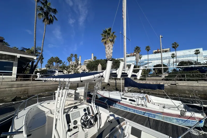 Slide: The Image of 2018 Robalo R200 Center Console boat docked near palm trees and buildings. - 3