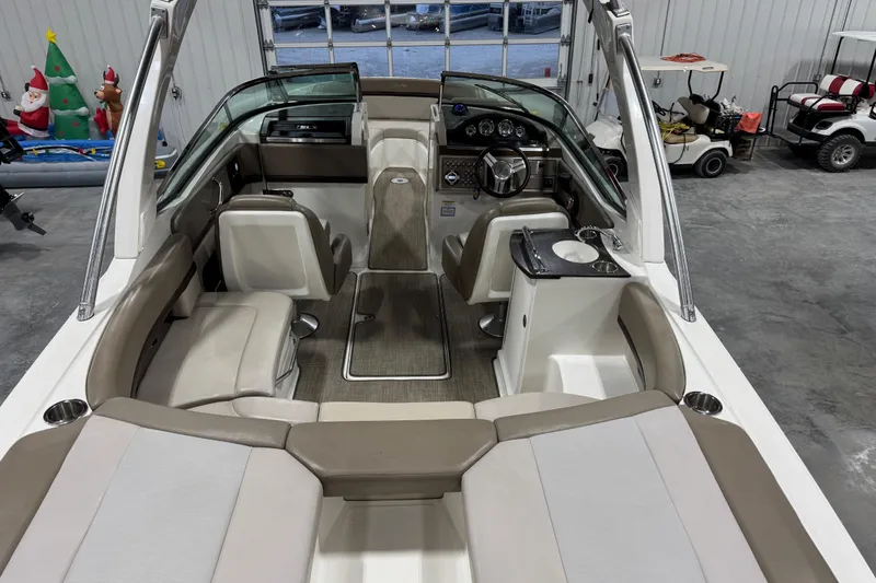 Slide: The Image of 2011 Sea Ray SLX 250 boat interior with seating, steering wheel, and dashboard in a garage setting. - 6
