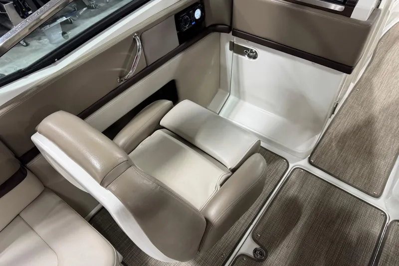Slide: The Image of 2011 Sea Ray SLX 250 interior with beige seating and carpeted flooring. - 8