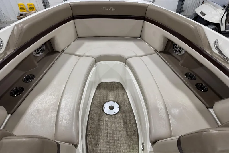 Slide: The Image of 2011 Sea Ray SLX 250 boat interior with beige seating and cup holders. - 9
