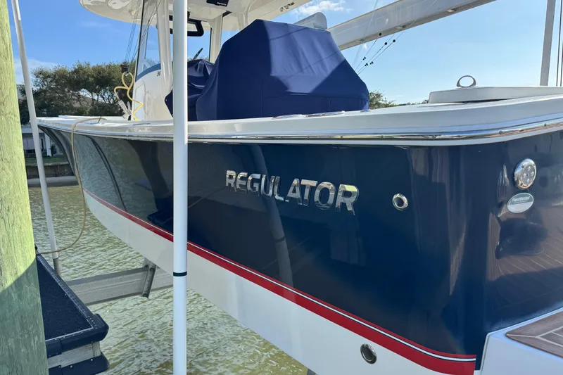 Slide: The Image of 2022 Regulator 34 boat docked, featuring sleek blue and white design. - 4