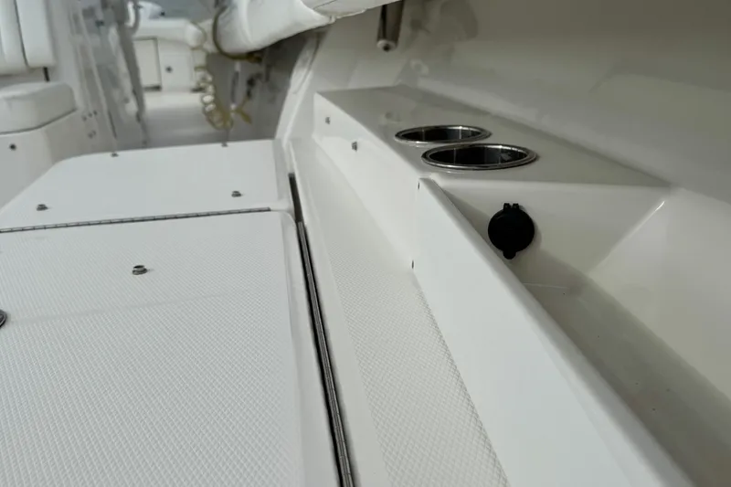 Slide: The Image of 2022 Regulator 34 boat compartment with open hatch and safety labels. - 44