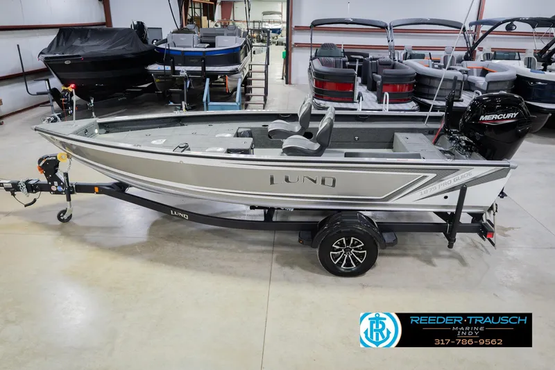 The Image of 2026 Lund 1875 Pro Guide fishing boat on trailer in showroom, side view. - 0