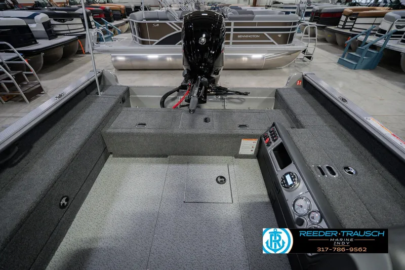 Slide: The Image of 2026 Lund 1875 Pro Guide boat interior with motor, displayed at Reeder-Trausch Marine showroom. - 17