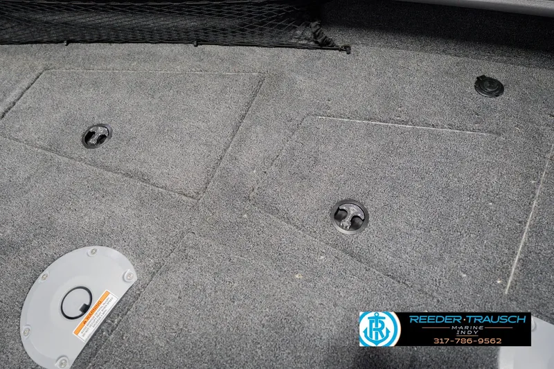 Slide: The Image of 2026 Lund 1875 Pro Guide boat interior with carpeted flooring and storage compartments. - 30