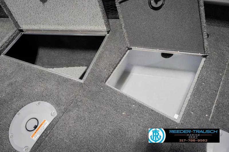 Slide: The Image of 2026 Lund 1875 Pro Guide boat storage compartments with carpeted interior and Reeder-Trausch Marine logo. - 32