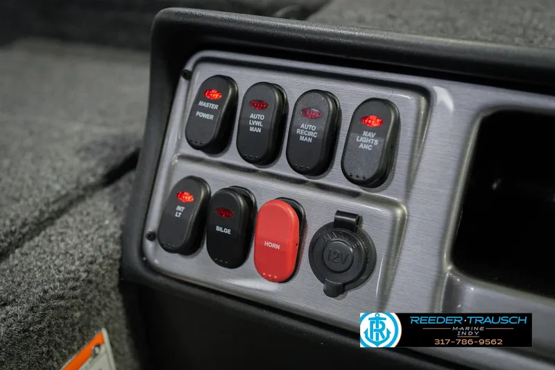 Slide: The Image of Control panel of 2026 Lund 1875 Pro Guide boat with various switches and 12V outlet. - 33
