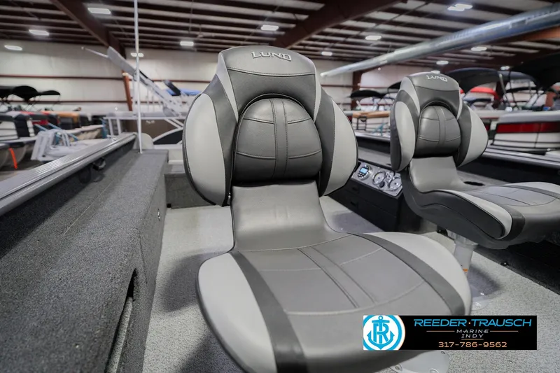 Slide: The Image of 2026 Lund 1875 Pro Guide boat interior with comfortable seating in showroom. - 37