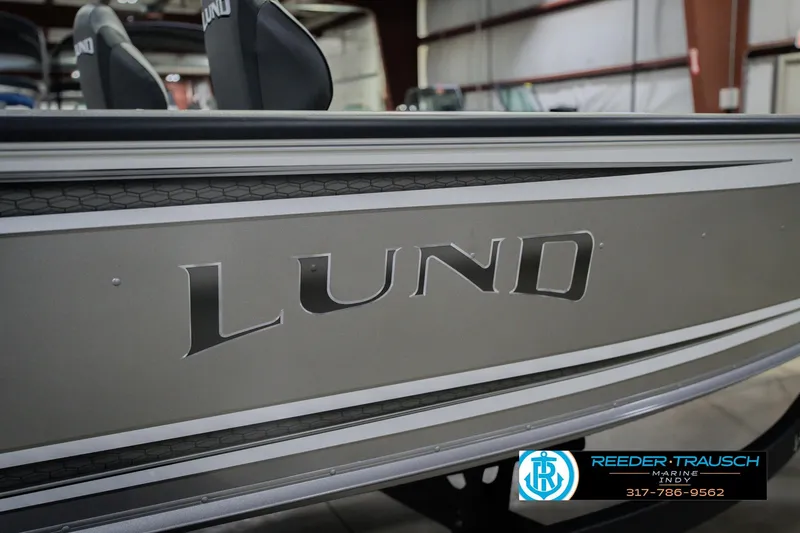 Slide: The Image of 2026 Lund 1875 Pro Guide boat side view in showroom with logo. - 49