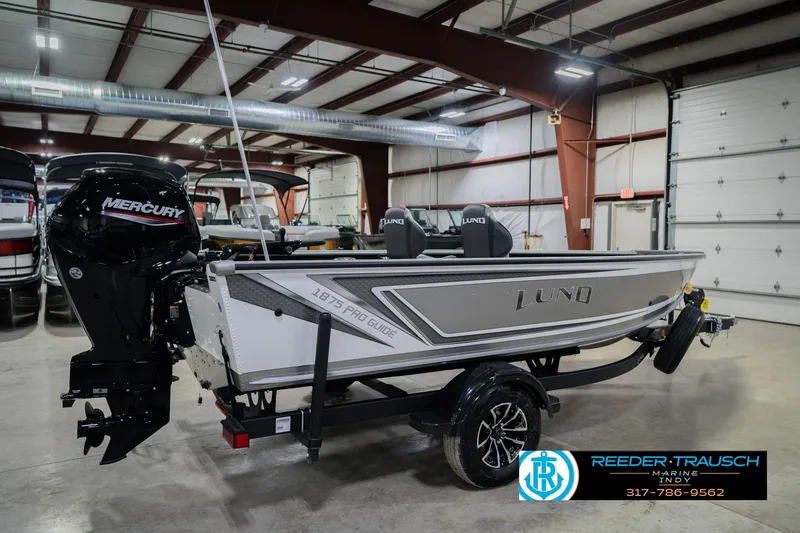 Slide: The Image of 2026 Lund 1875 Pro Guide boat in showroom with Mercury engine. - 5