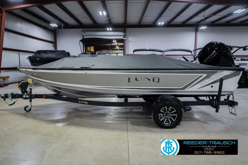 Slide: The Image of 2026 Lund 1875 Pro Guide boat with cover in indoor showroom. - 62